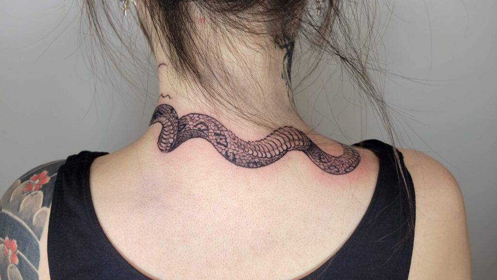 snake tattoo on the back of the neck of a female